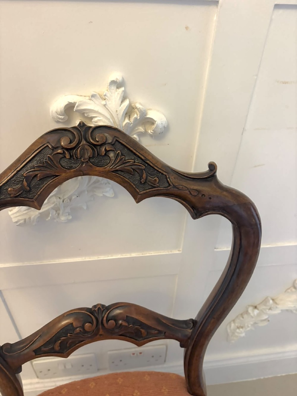A pair of Victorian carved walnut side chairs featuring open balloon backs with foliate carvings, cabriole legs, and terracotta patterned fabric upholstered seats. View XII