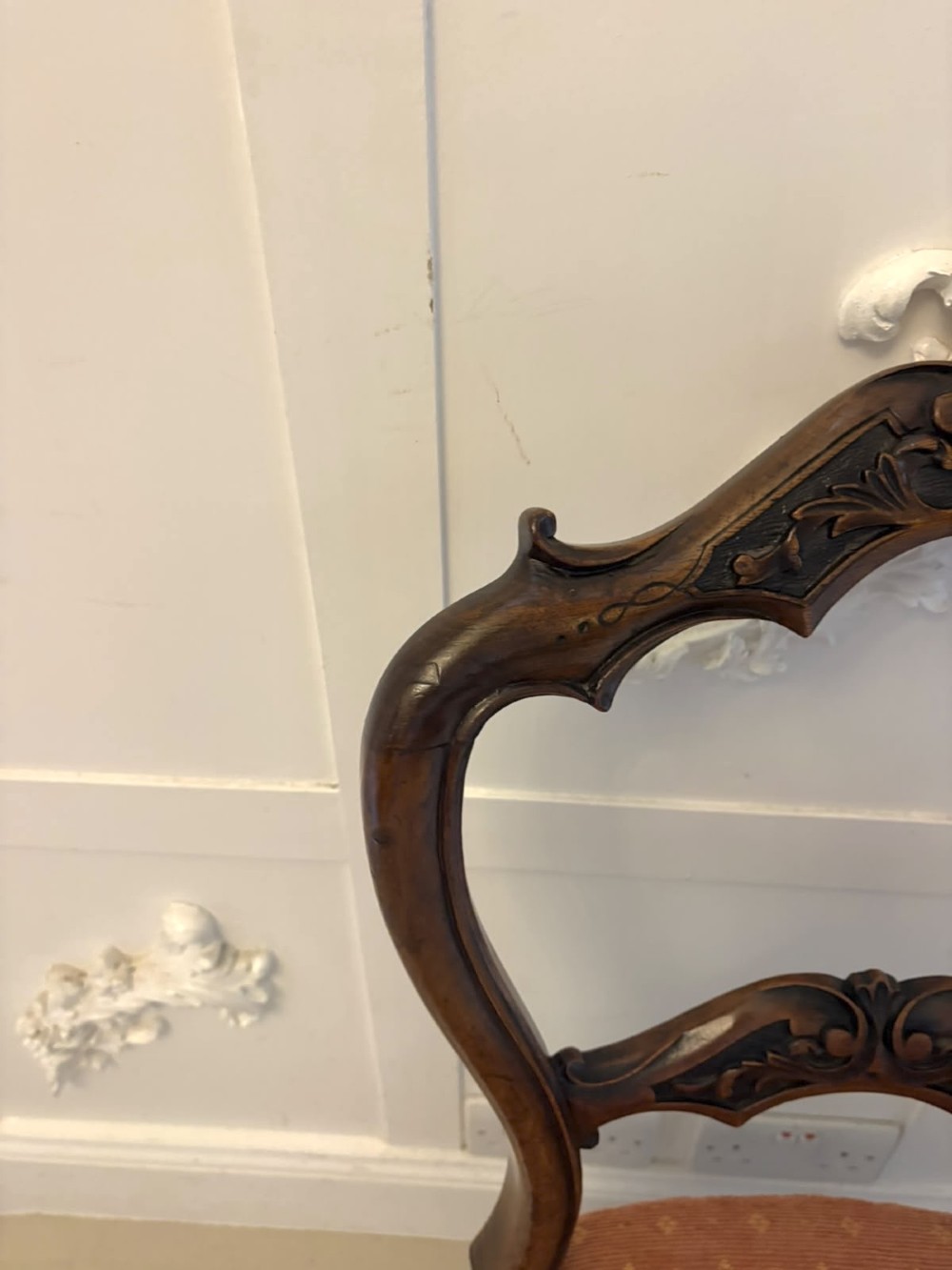 A pair of Victorian carved walnut side chairs featuring open balloon backs with foliate carvings, cabriole legs, and terracotta patterned fabric upholstered seats. View XIV