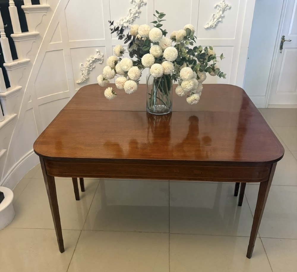 A pair of Georgian mahogany console tables featuring rounded corners, inlaid aprons, and slender tapered legs. View III