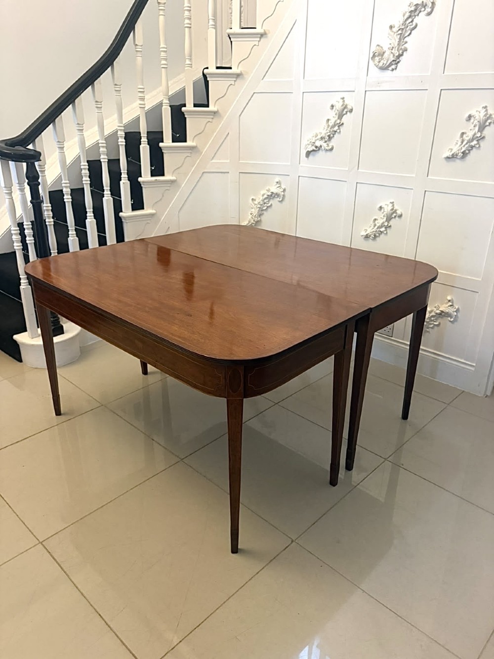 A pair of Georgian mahogany console tables featuring rounded corners, inlaid aprons, and slender tapered legs. View IV