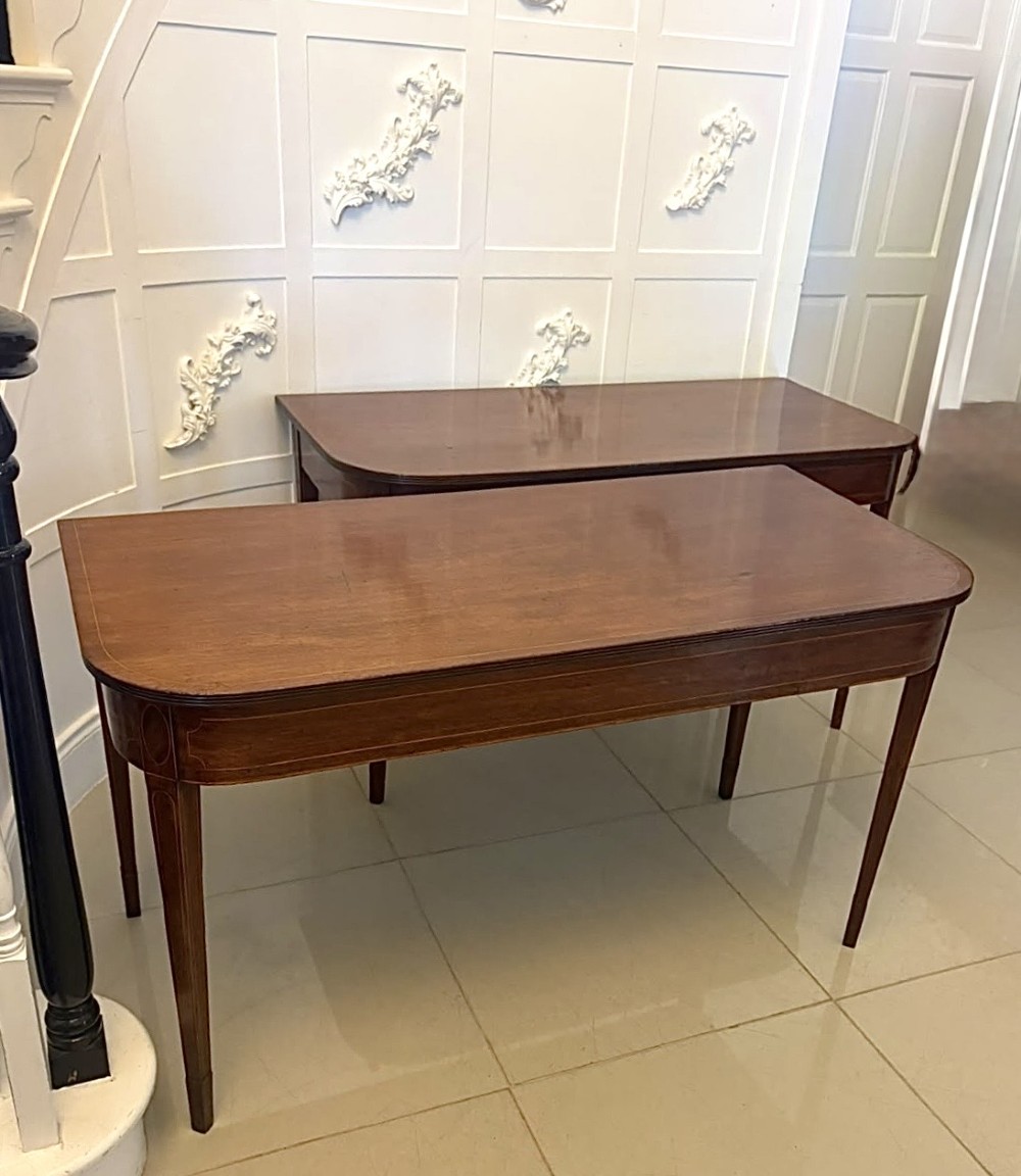 A pair of Georgian mahogany console tables featuring rounded corners, inlaid aprons, and slender tapered legs. View XII