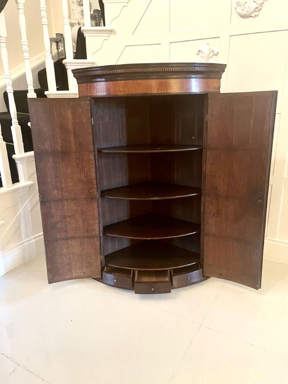 An 18th-century George III bow-fronted corner cabinet crafted from plum pudding mahogany with brass H-hinges. View III