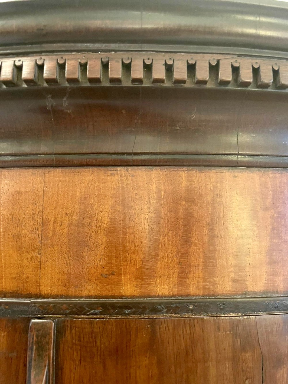 An 18th-century George III bow-fronted corner cabinet crafted from plum pudding mahogany with brass H-hinges. View VII