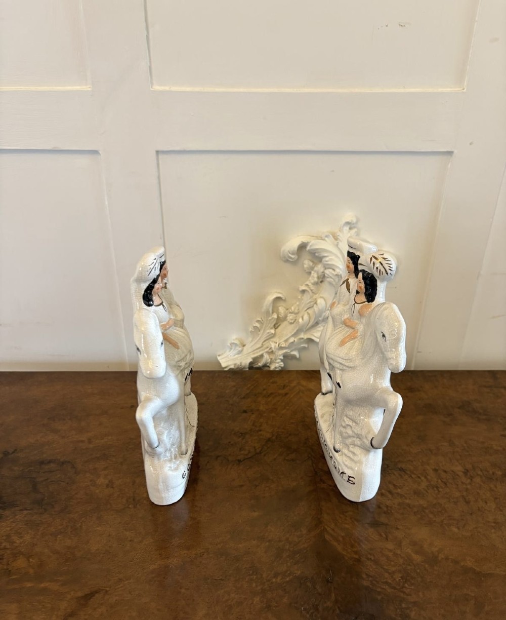 A pair of off-white antique Staffordshire flatback ceramic figures featuring riders on horseback titled Going to Market and Returning Home. View III