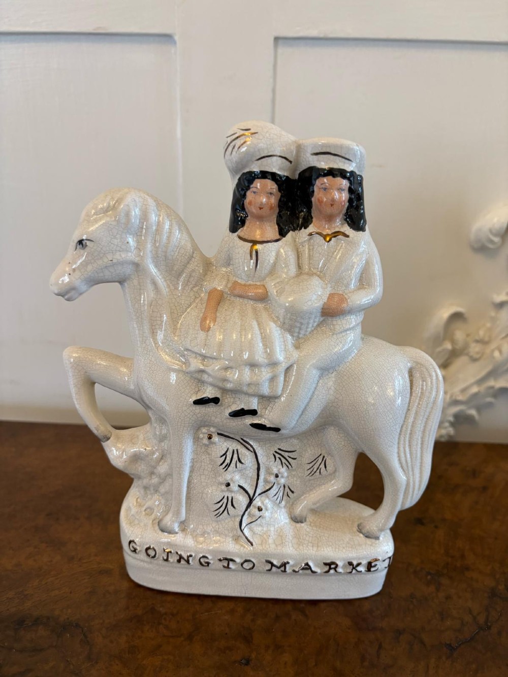 A pair of off-white antique Staffordshire flatback ceramic figures featuring riders on horseback titled Going to Market and Returning Home. View XII