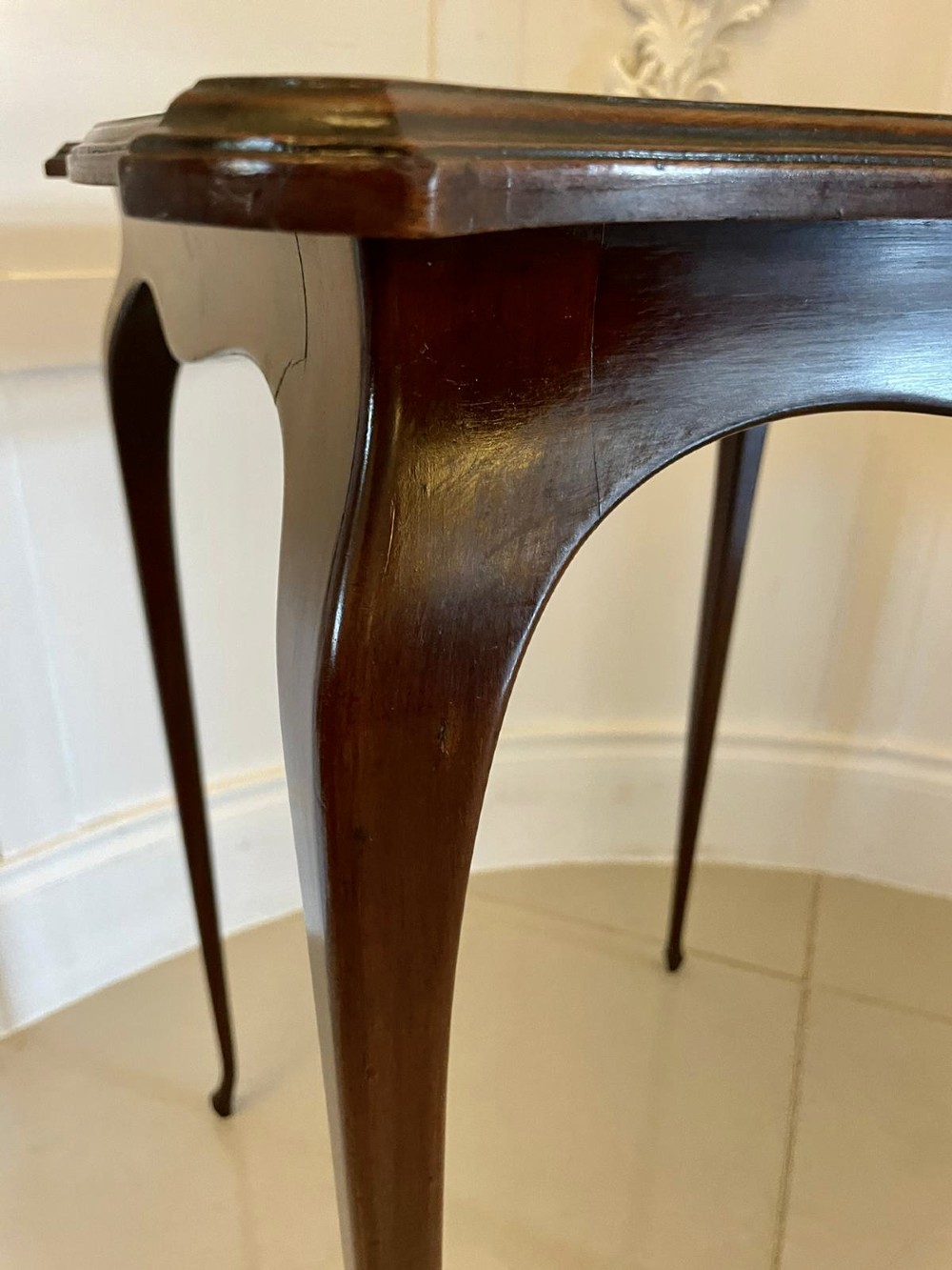 A Victorian mahogany side table featuring detailed marquetry inlay of musical instruments on a serpentine top supported by four cabriole legs. View VI