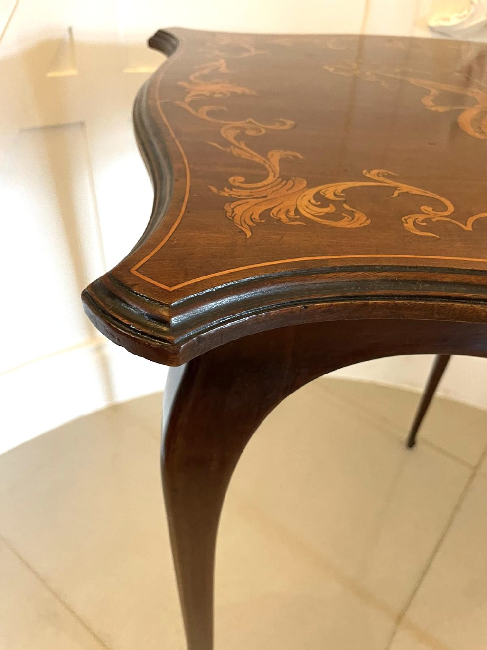 A Victorian mahogany side table featuring detailed marquetry inlay of musical instruments on a serpentine top supported by four cabriole legs. View VII