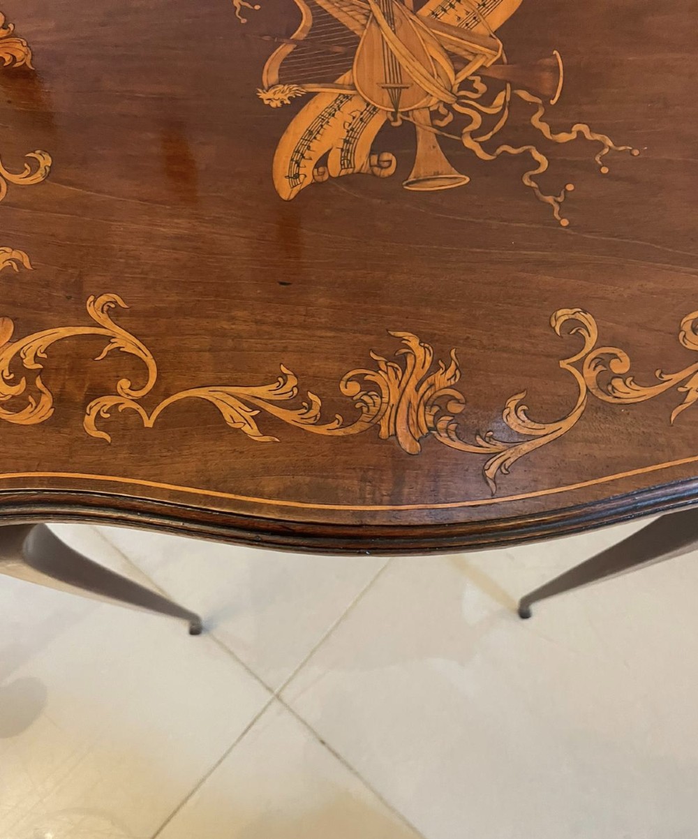A Victorian mahogany side table featuring detailed marquetry inlay of musical instruments on a serpentine top supported by four cabriole legs. View VIII