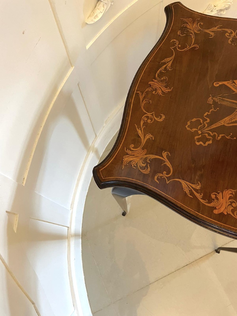 A Victorian mahogany side table featuring detailed marquetry inlay of musical instruments on a serpentine top supported by four cabriole legs. View X