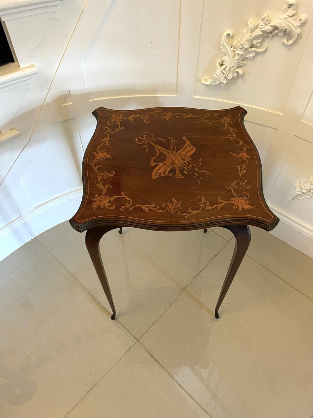 A Victorian mahogany side table featuring detailed marquetry inlay of musical instruments on a serpentine top supported by four cabriole legs. View XIII