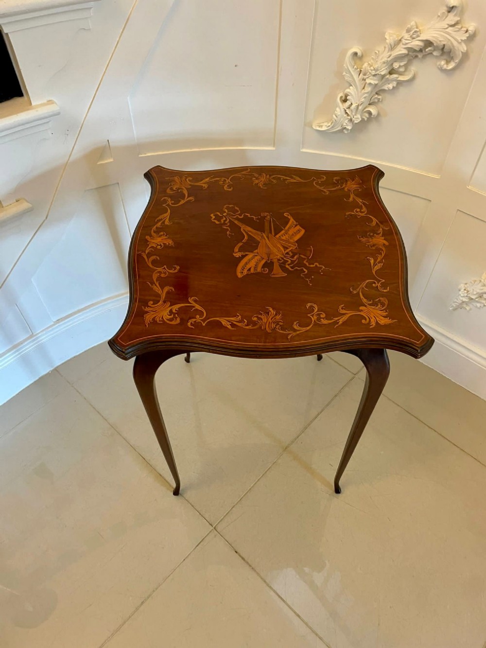A Victorian mahogany side table featuring detailed marquetry inlay of musical instruments on a serpentine top supported by four cabriole legs. View XIV