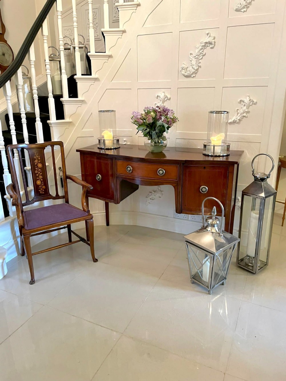 An Edwardian inlaid mahogany serpentine sideboard featuring a central drawer, flanking cupboard doors, brass circular handles, and tapered legs. View VIII
