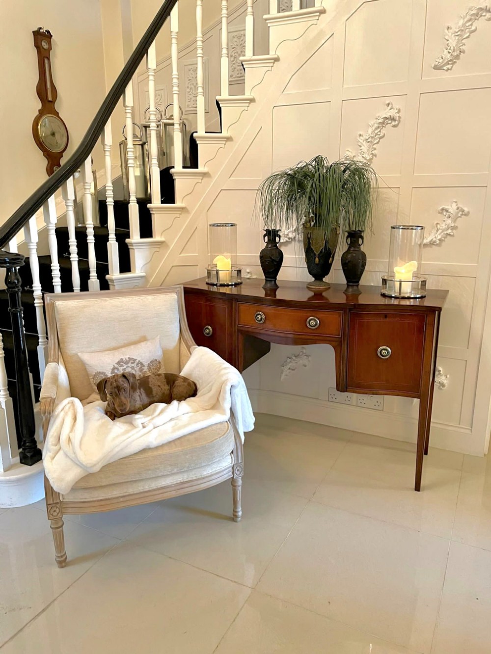 An Edwardian inlaid mahogany serpentine sideboard featuring a central drawer, flanking cupboard doors, brass circular handles, and tapered legs. View IX