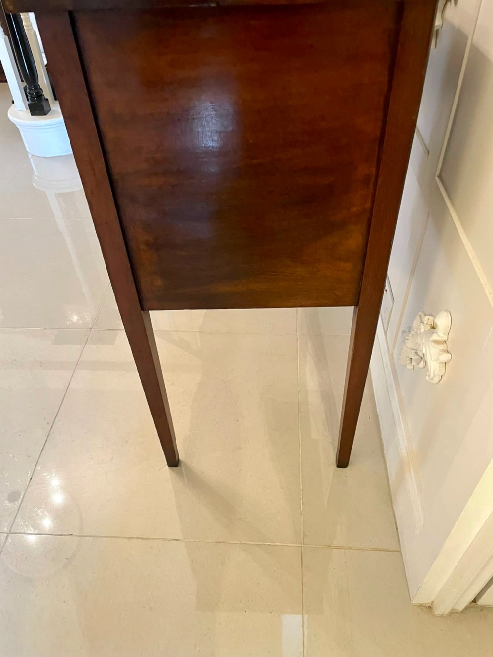 An Edwardian inlaid mahogany serpentine sideboard featuring a central drawer, flanking cupboard doors, brass circular handles, and tapered legs. View X