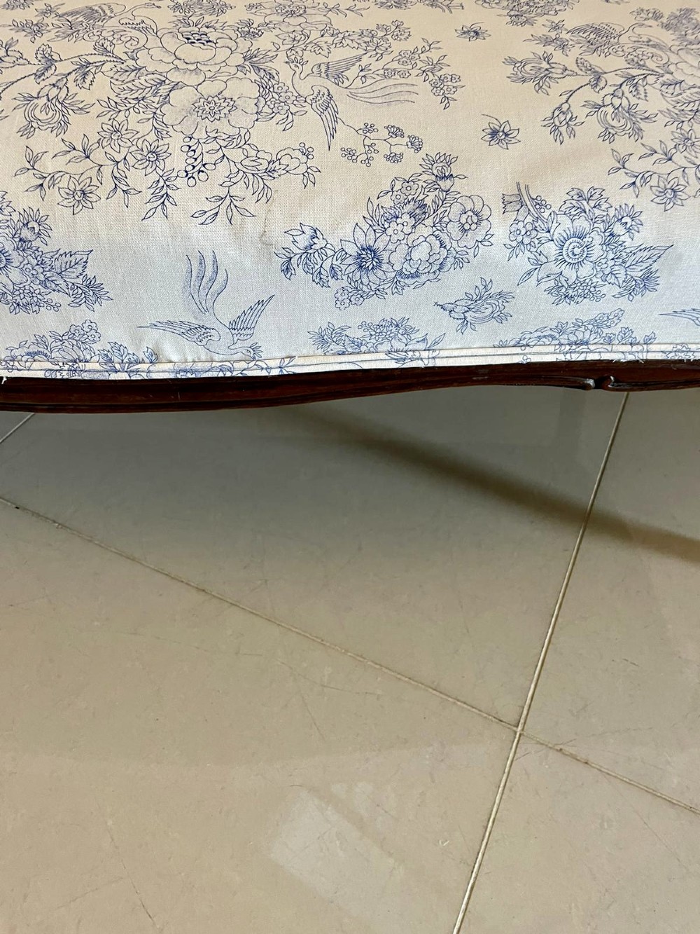 A Victorian carved mahogany settee featuring upholstered blue and white floral pattern seat and backrest, padded armrests, and carved cabriole legs. View IX