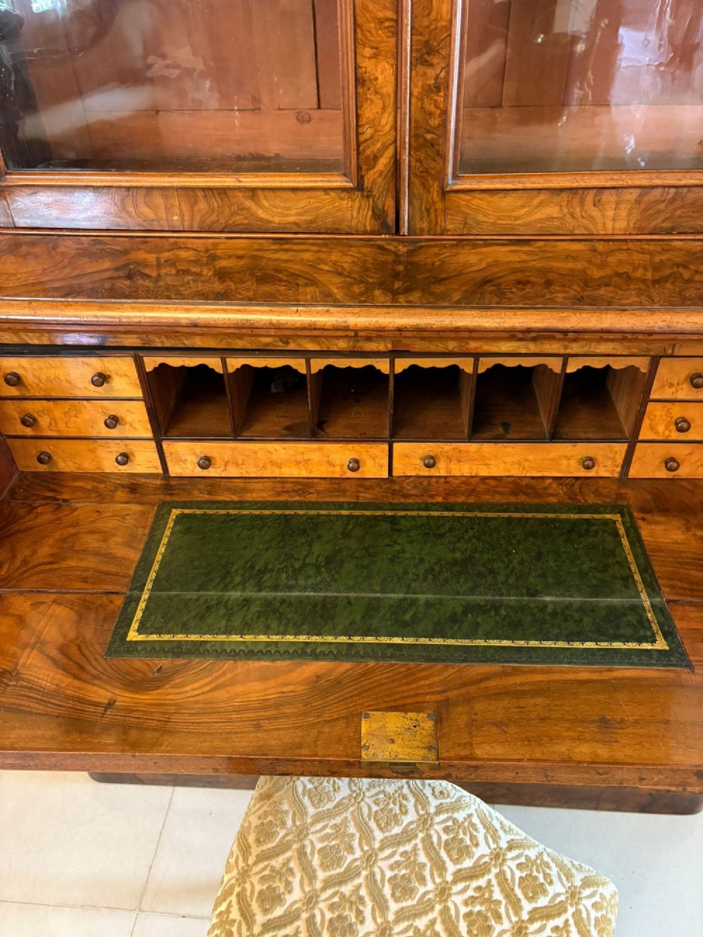 A Victorian burr walnut secretaire bookcase featuring a glazed upper cabinet with two doors, a deep secretaire drawer with turned wooden handles, and a two-door cupboard base. View II