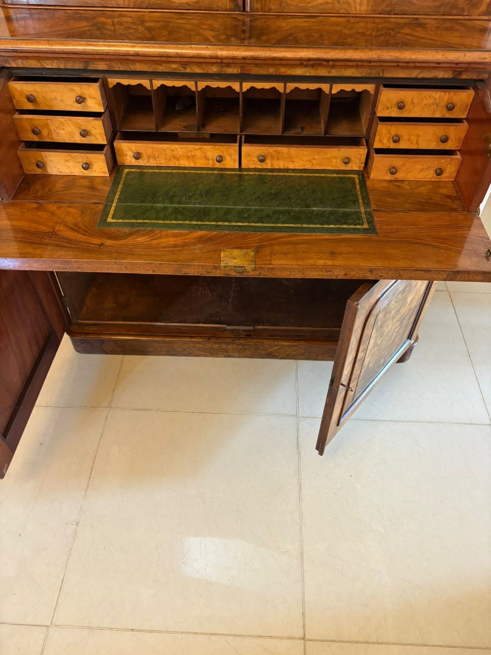 A Victorian burr walnut secretaire bookcase featuring a glazed upper cabinet with two doors, a deep secretaire drawer with turned wooden handles, and a two-door cupboard base. View III