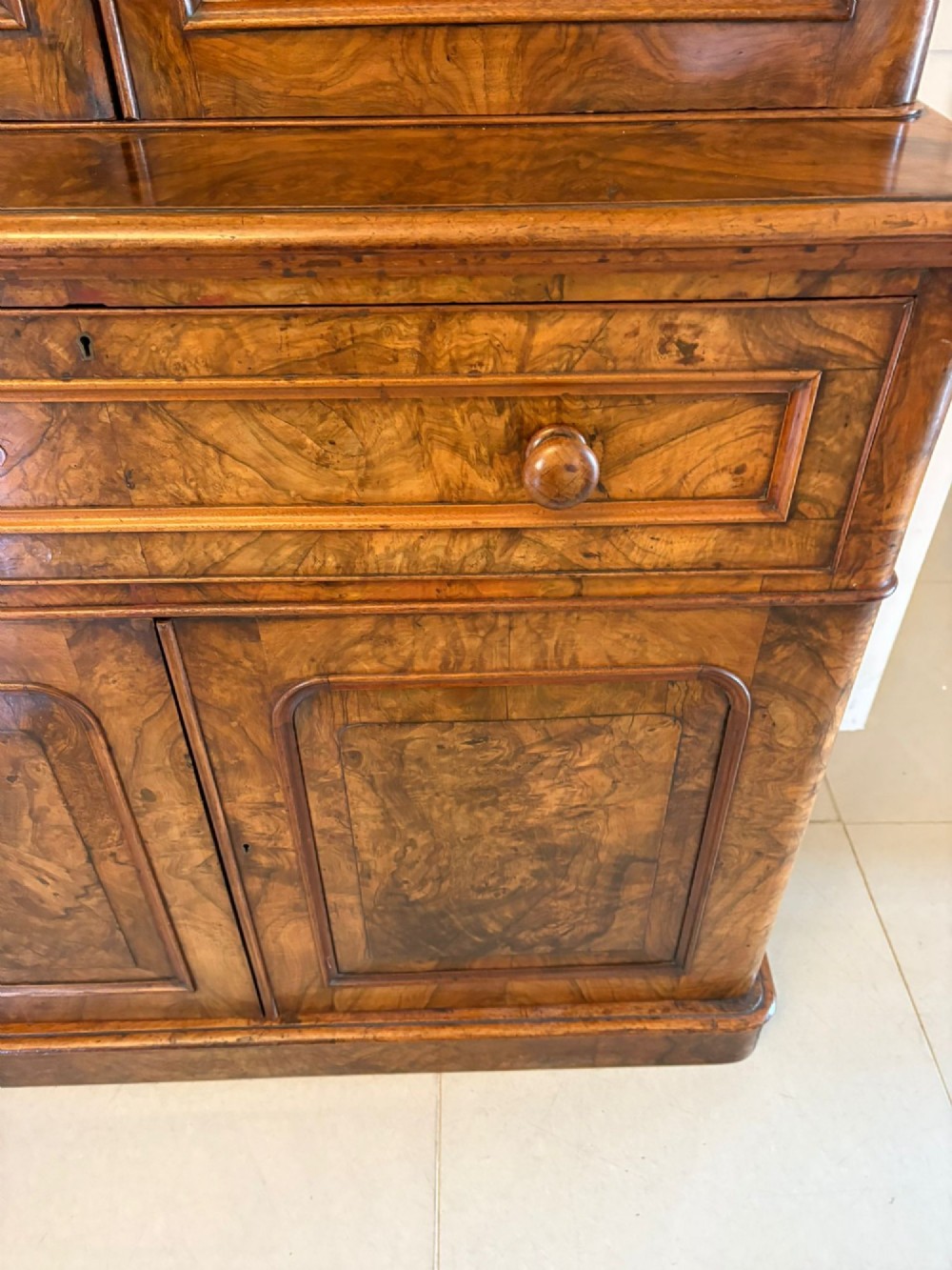 A Victorian burr walnut secretaire bookcase featuring a glazed upper cabinet with two doors, a deep secretaire drawer with turned wooden handles, and a two-door cupboard base. View XI