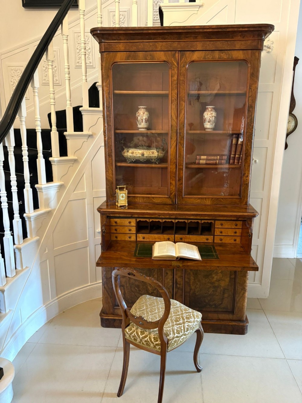 A Victorian burr walnut secretaire bookcase featuring a glazed upper cabinet with two doors, a deep secretaire drawer with turned wooden handles, and a two-door cupboard base. View XII