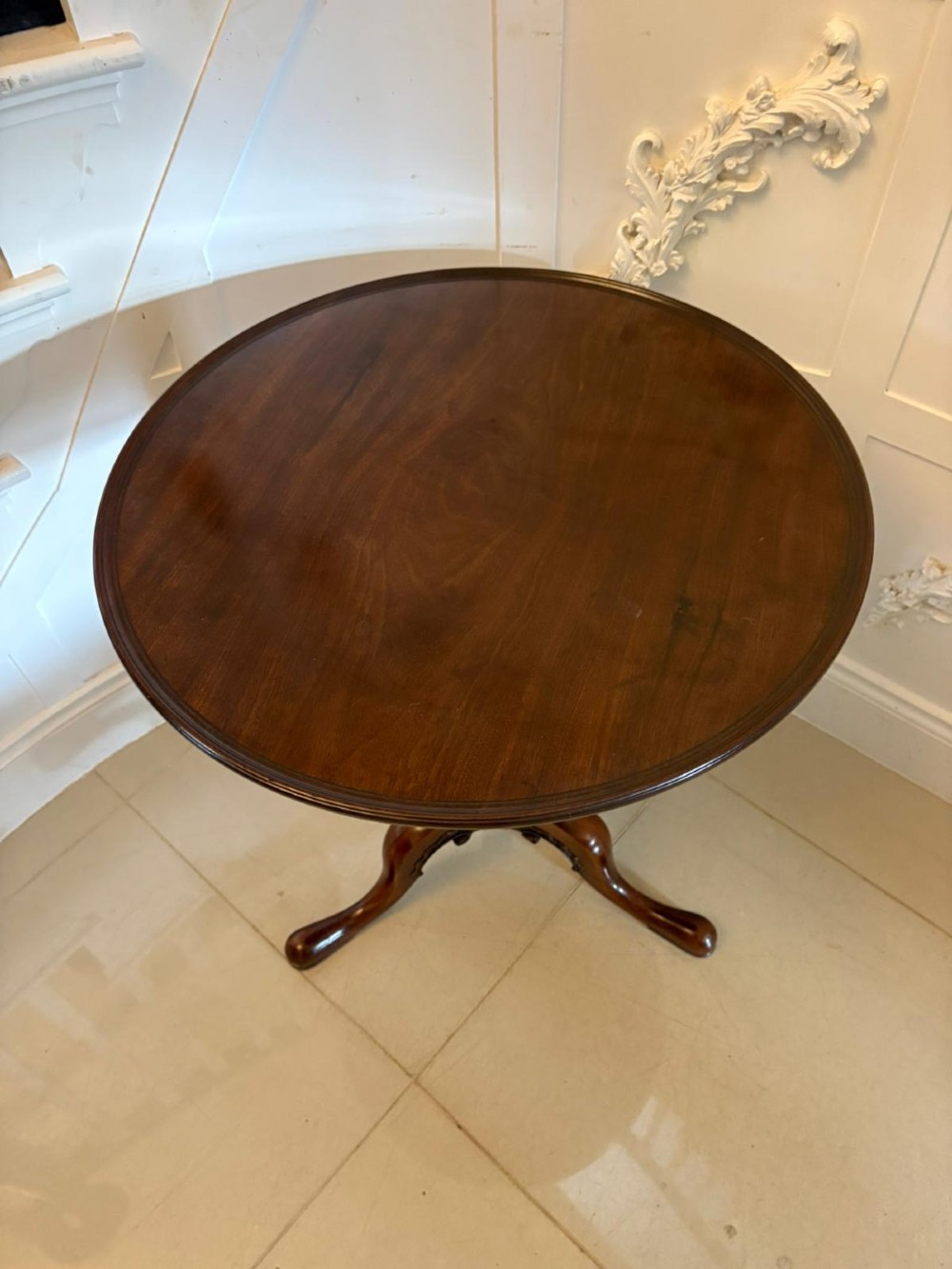 A Georgian mahogany tripod table with a circular top mounted on a turned pedestal with three cabriole legs. View II