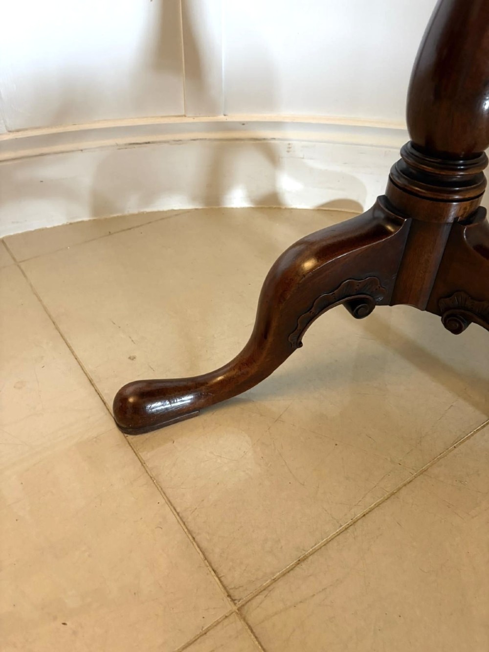 A Georgian mahogany tripod table with a circular top mounted on a turned pedestal with three cabriole legs. View IV