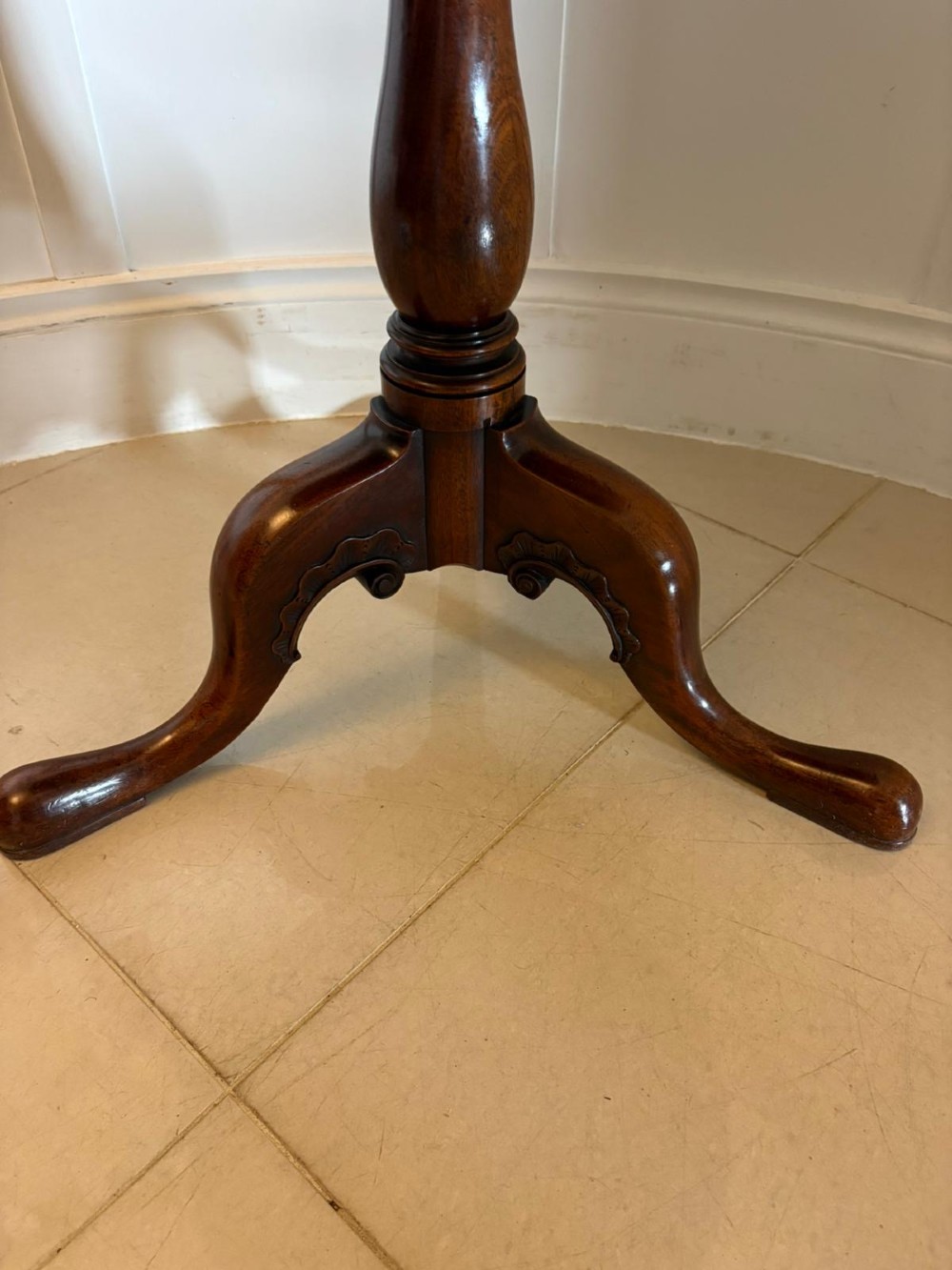 A Georgian mahogany tripod table with a circular top mounted on a turned pedestal with three cabriole legs. View V