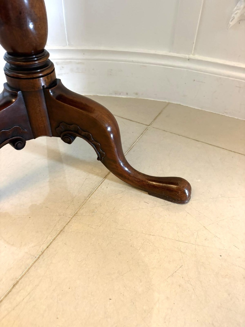 A Georgian mahogany tripod table with a circular top mounted on a turned pedestal with three cabriole legs. View VI