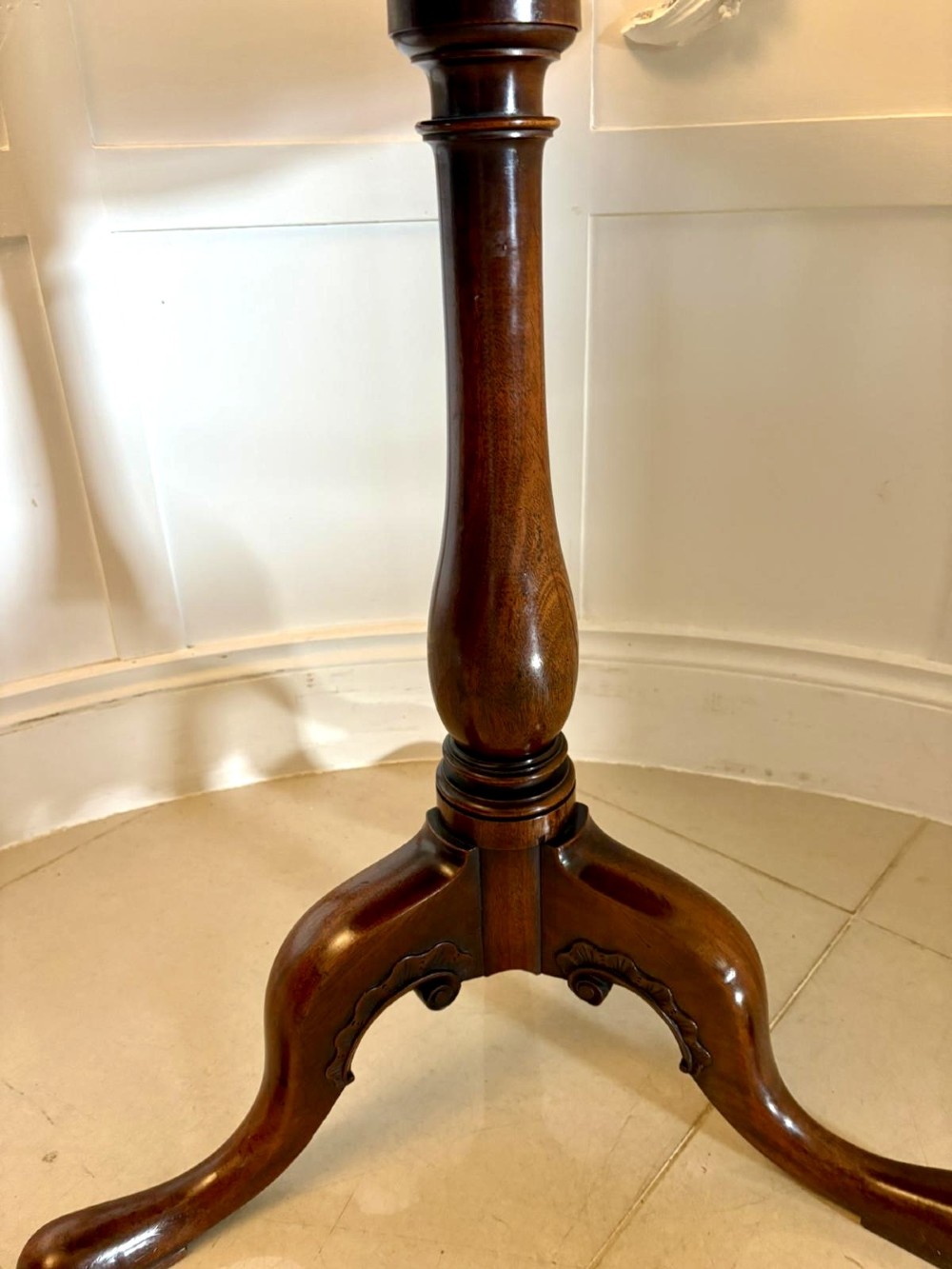 A Georgian mahogany tripod table with a circular top mounted on a turned pedestal with three cabriole legs. View VII