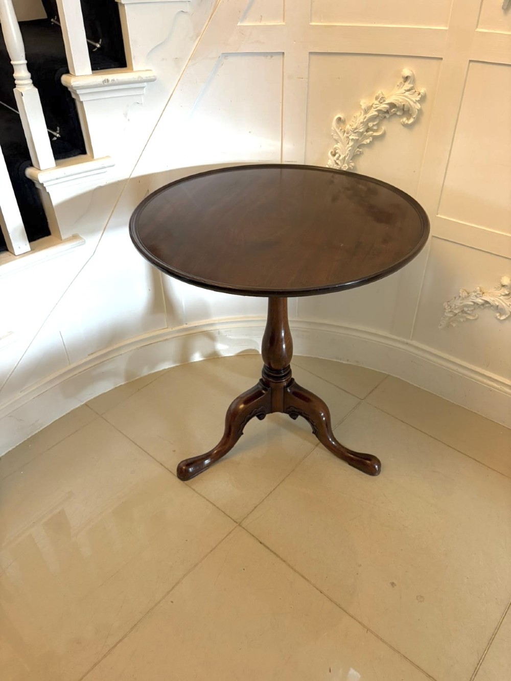 A Georgian mahogany tripod table with a circular top mounted on a turned pedestal with three cabriole legs.