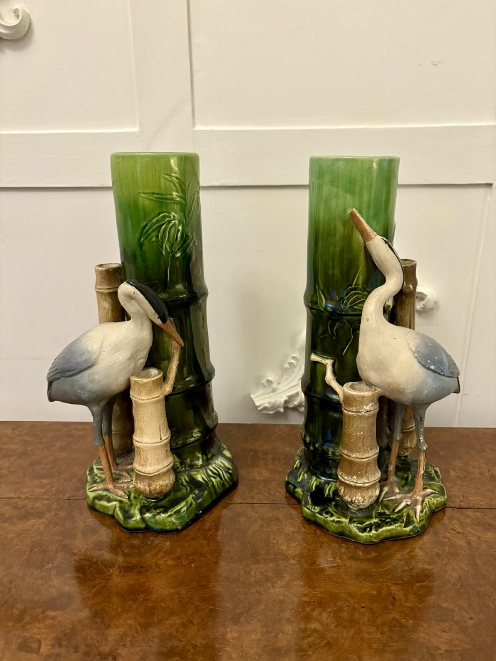 A pair of Victorian green glazed ceramic vases featuring bamboo stems and sculpted wading birds.