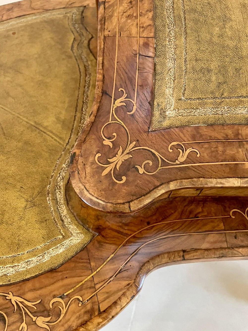 A Victorian burr walnut kidney-shaped writing table with floral marquetry inlay, green leather panels, and a central raised writing slope. View V