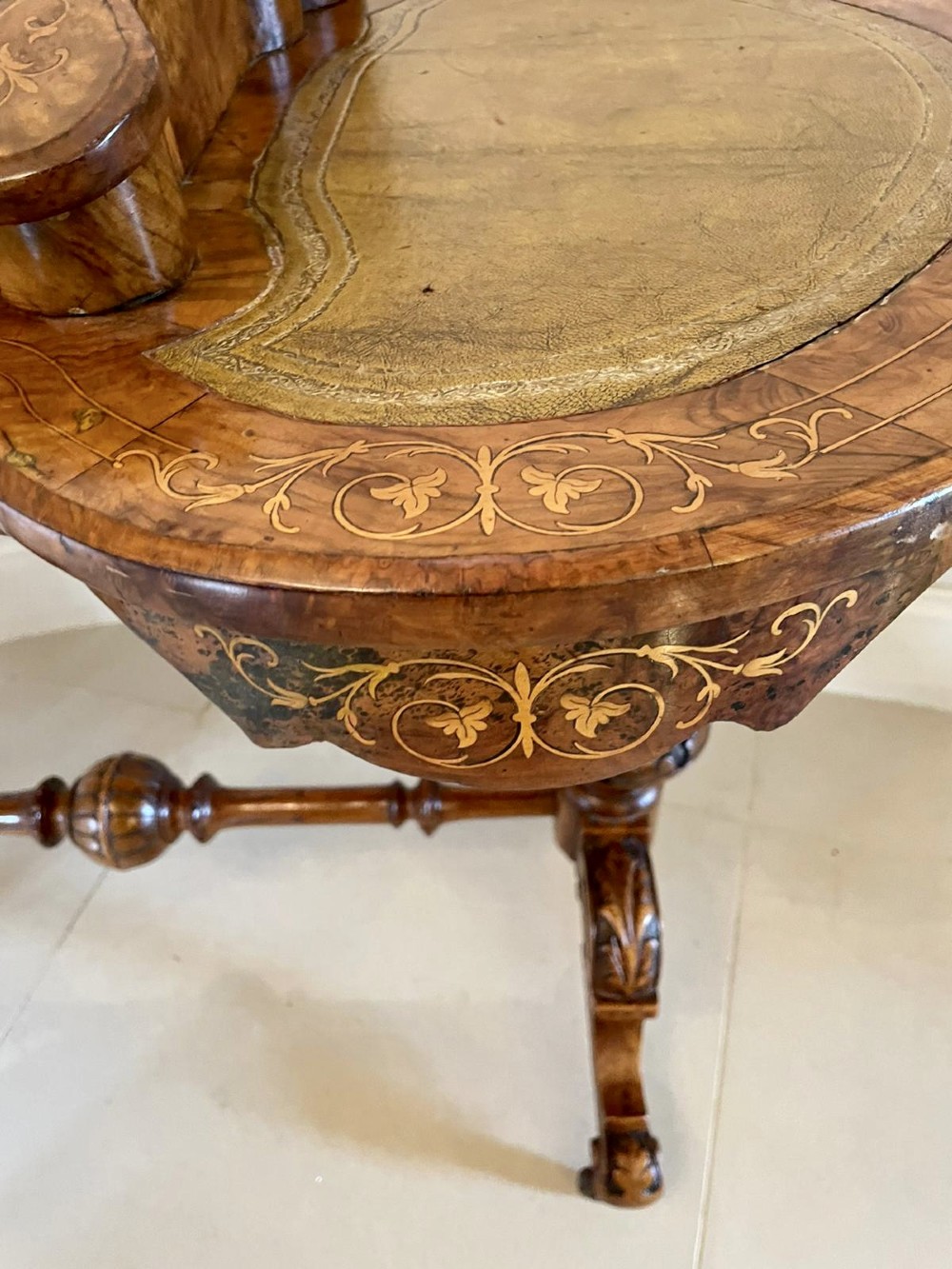 A Victorian burr walnut kidney-shaped writing table with floral marquetry inlay, green leather panels, and a central raised writing slope. View VI