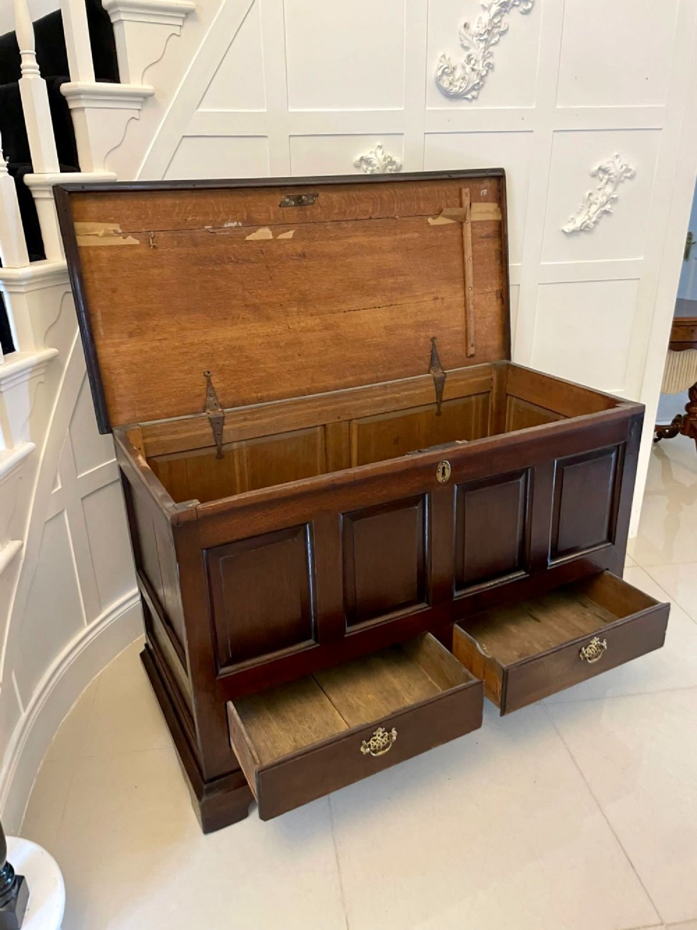 An 18th-century dark oak mule chest featuring four panelled facade sections above two lower drawers with brass handles. View VII