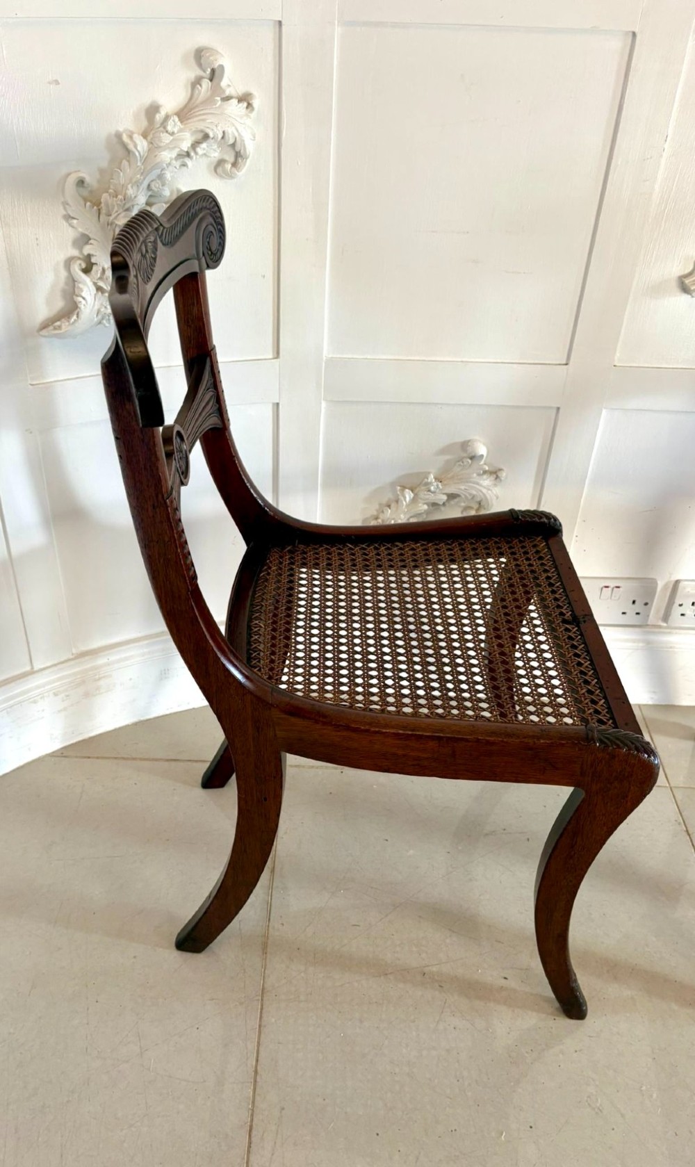 A set of six Regency mahogany dining chairs featuring carved bar-back crest rails, rosettes, and green tartan fabric upholstery. View III