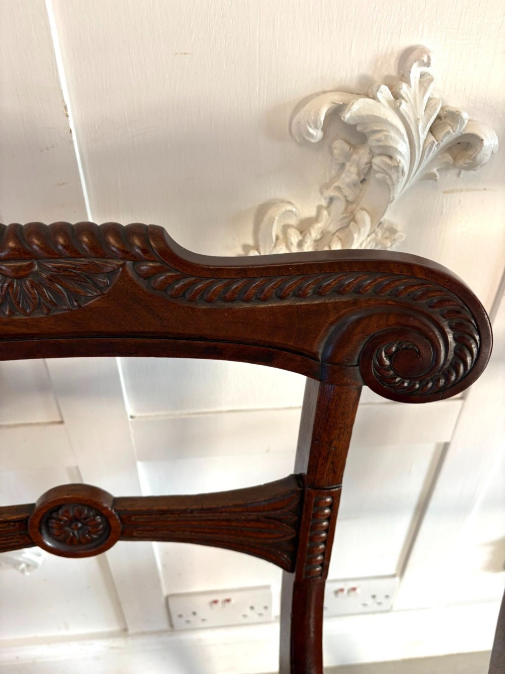 A set of six Regency mahogany dining chairs featuring carved bar-back crest rails, rosettes, and green tartan fabric upholstery. View V