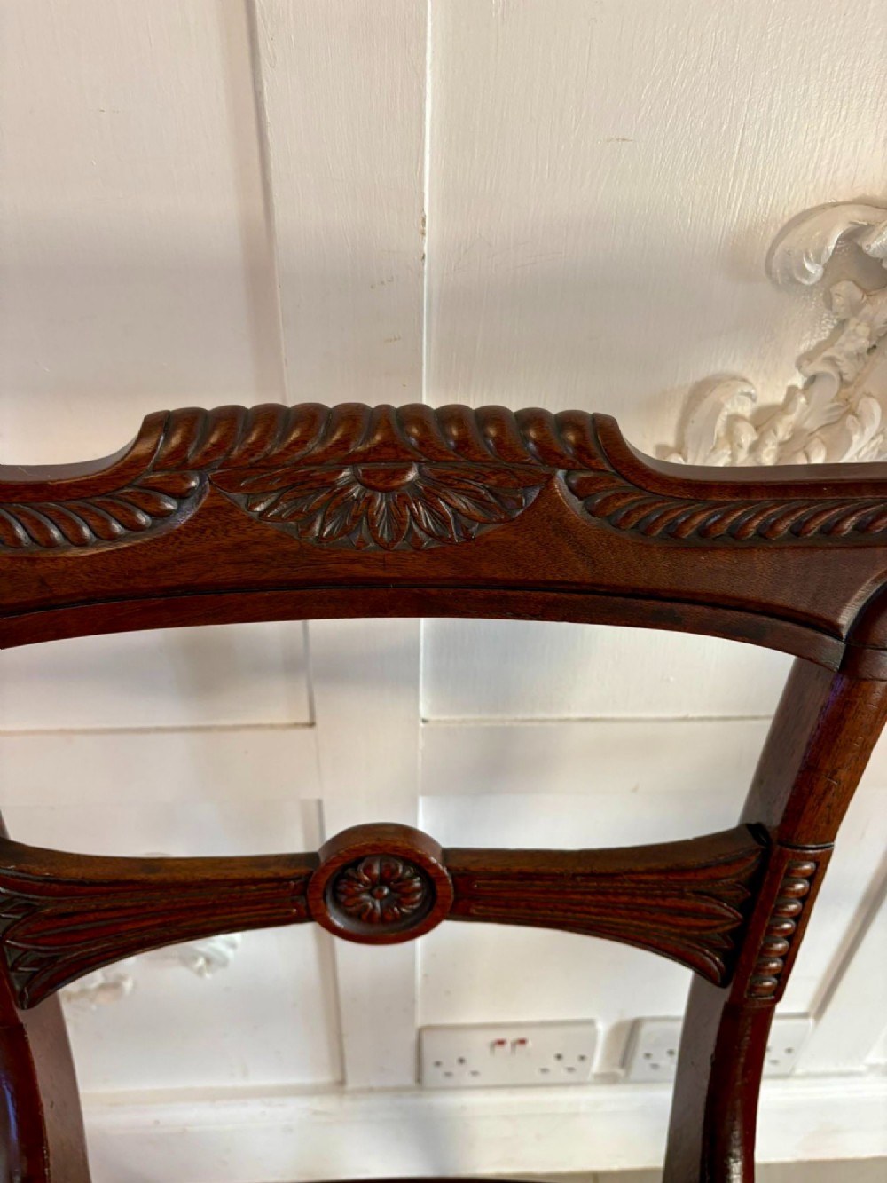 A set of six Regency mahogany dining chairs featuring carved bar-back crest rails, rosettes, and green tartan fabric upholstery. View VI