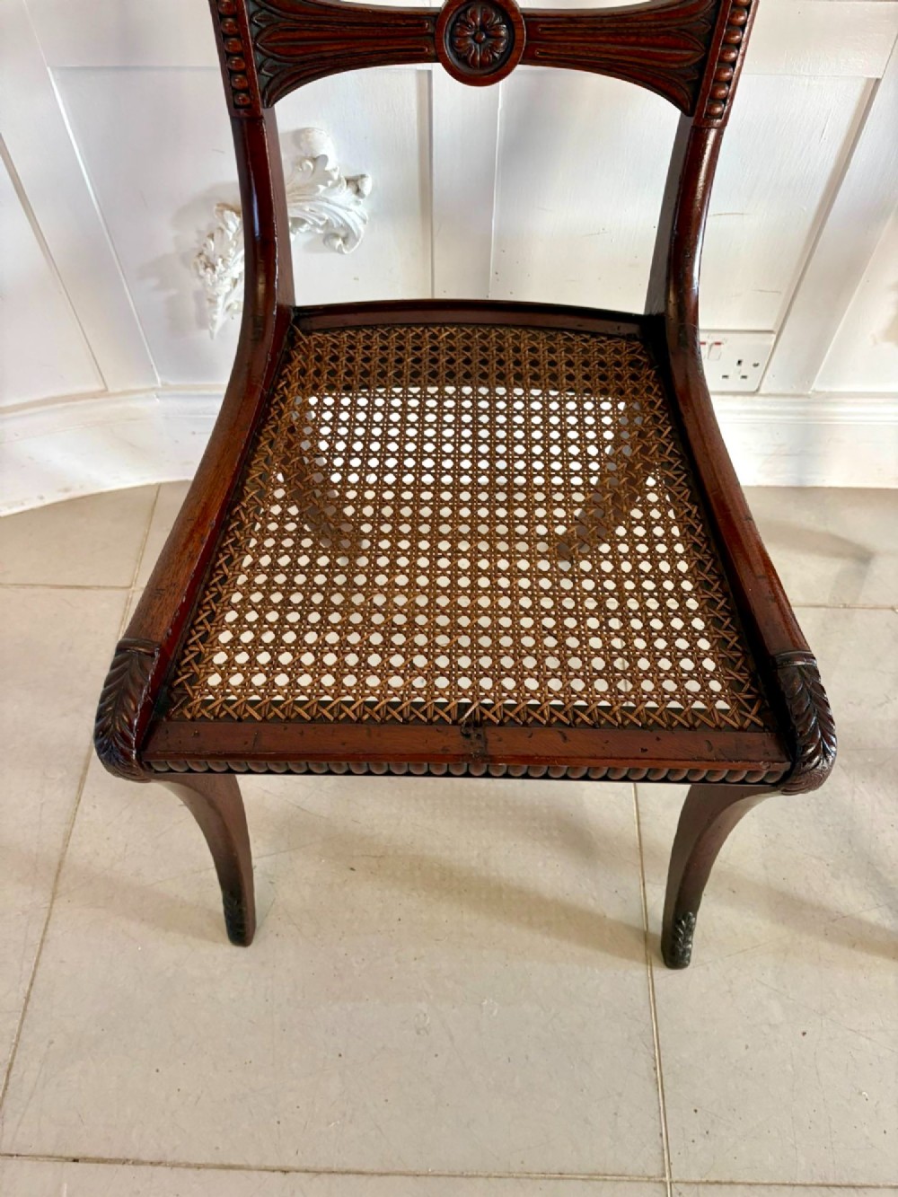 A set of six Regency mahogany dining chairs featuring carved bar-back crest rails, rosettes, and green tartan fabric upholstery. View IX