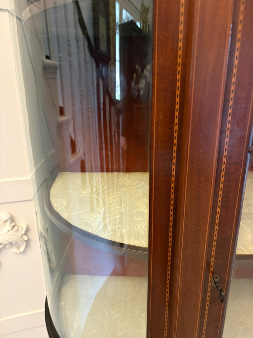 An Edwardian mahogany display cabinet featuring bow-ended glass sides, a central astragal glazed door, and satinwood marquetry inlay. View VI
