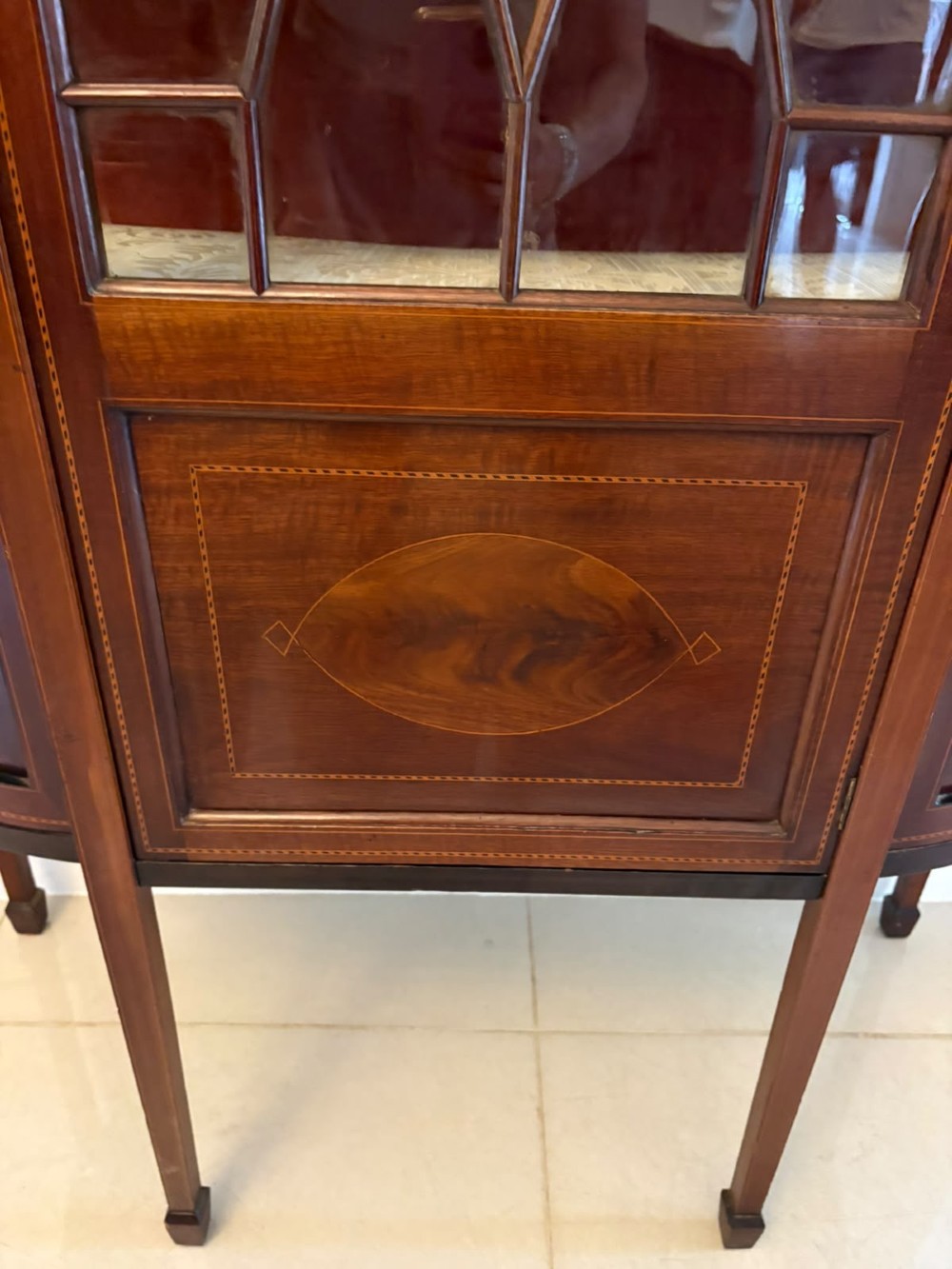 An Edwardian mahogany display cabinet featuring bow-ended glass sides, a central astragal glazed door, and satinwood marquetry inlay. View X