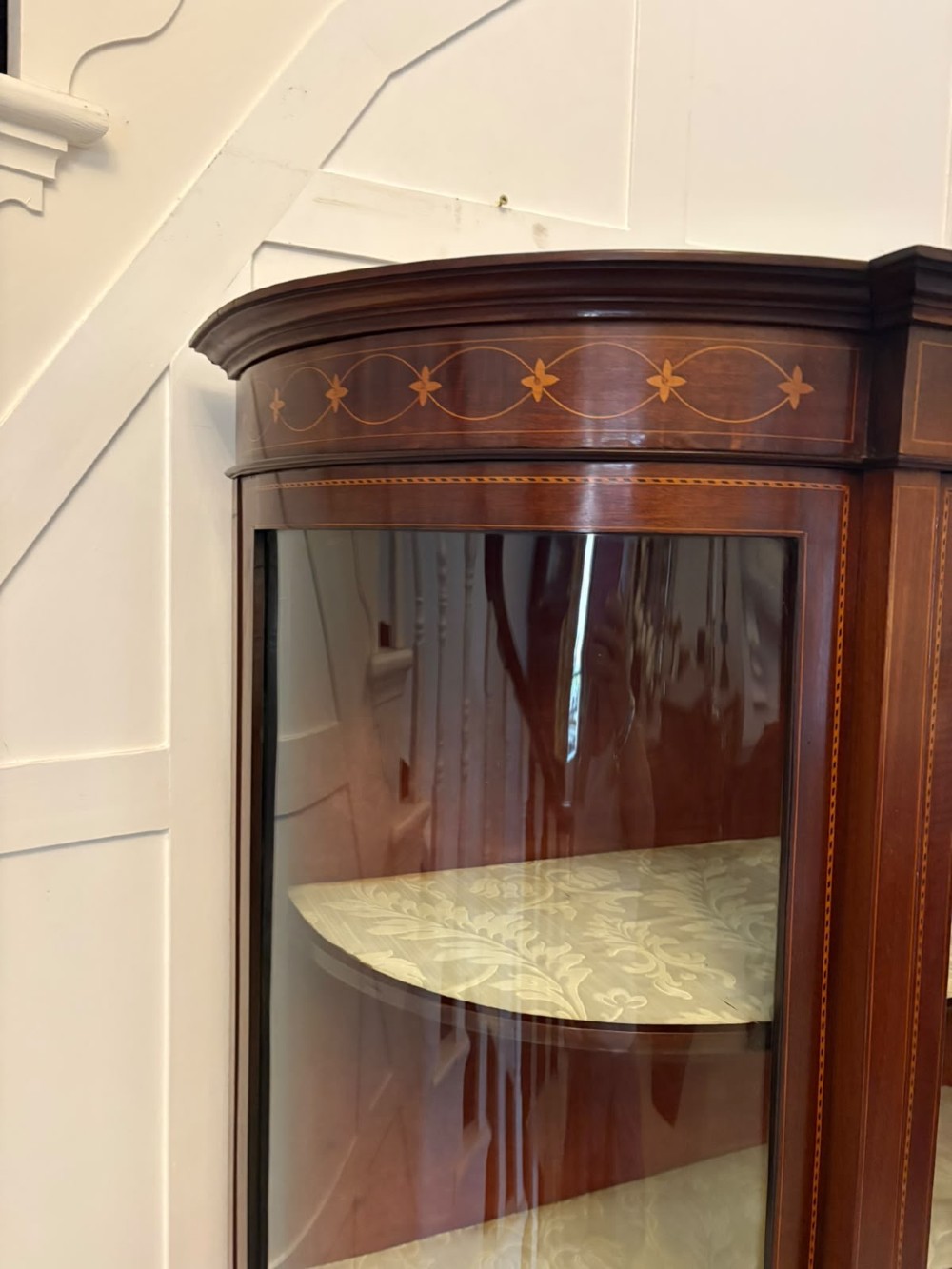 An Edwardian mahogany display cabinet featuring bow-ended glass sides, a central astragal glazed door, and satinwood marquetry inlay. View XI