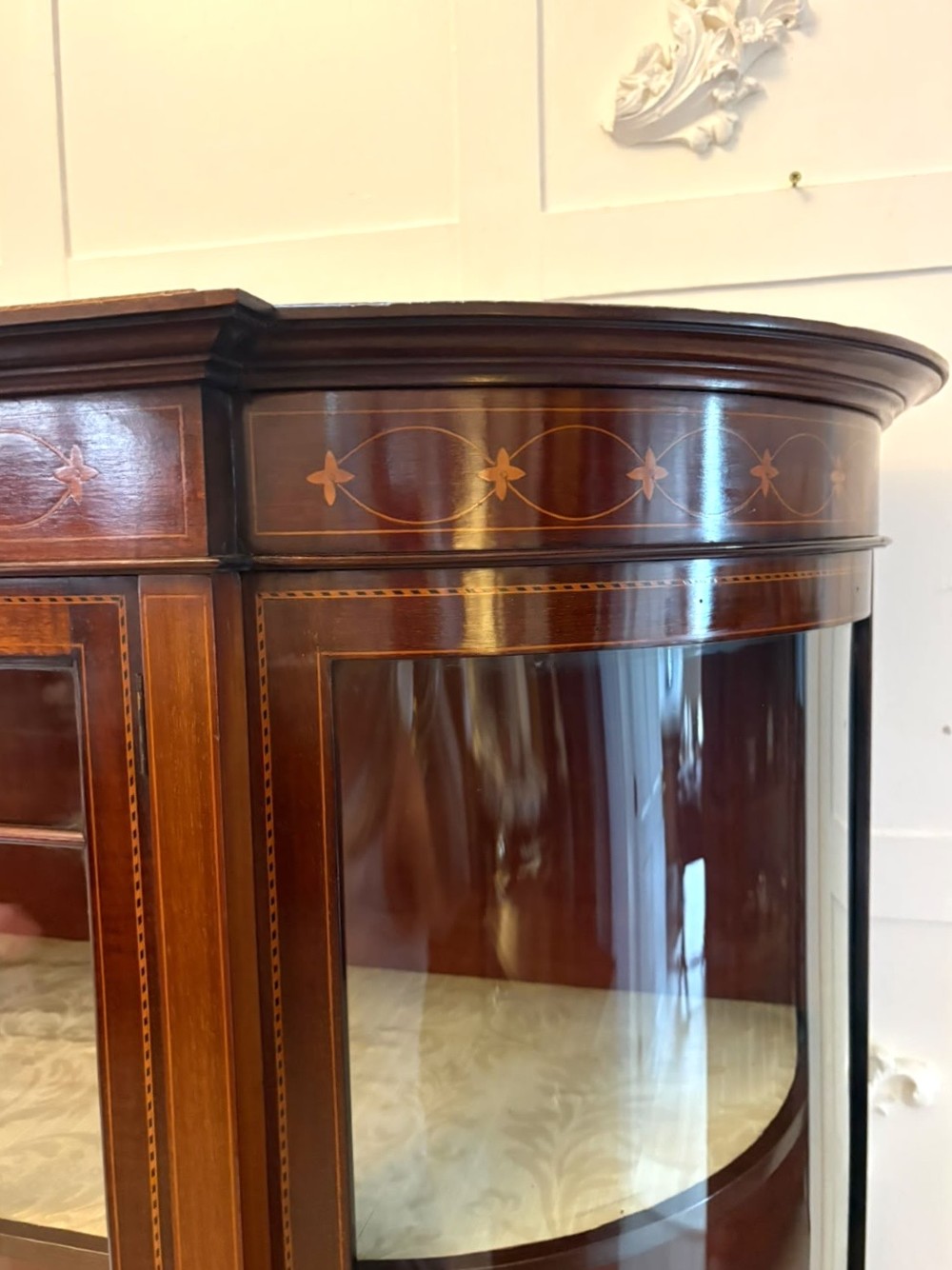 An Edwardian mahogany display cabinet featuring bow-ended glass sides, a central astragal glazed door, and satinwood marquetry inlay. View XIII