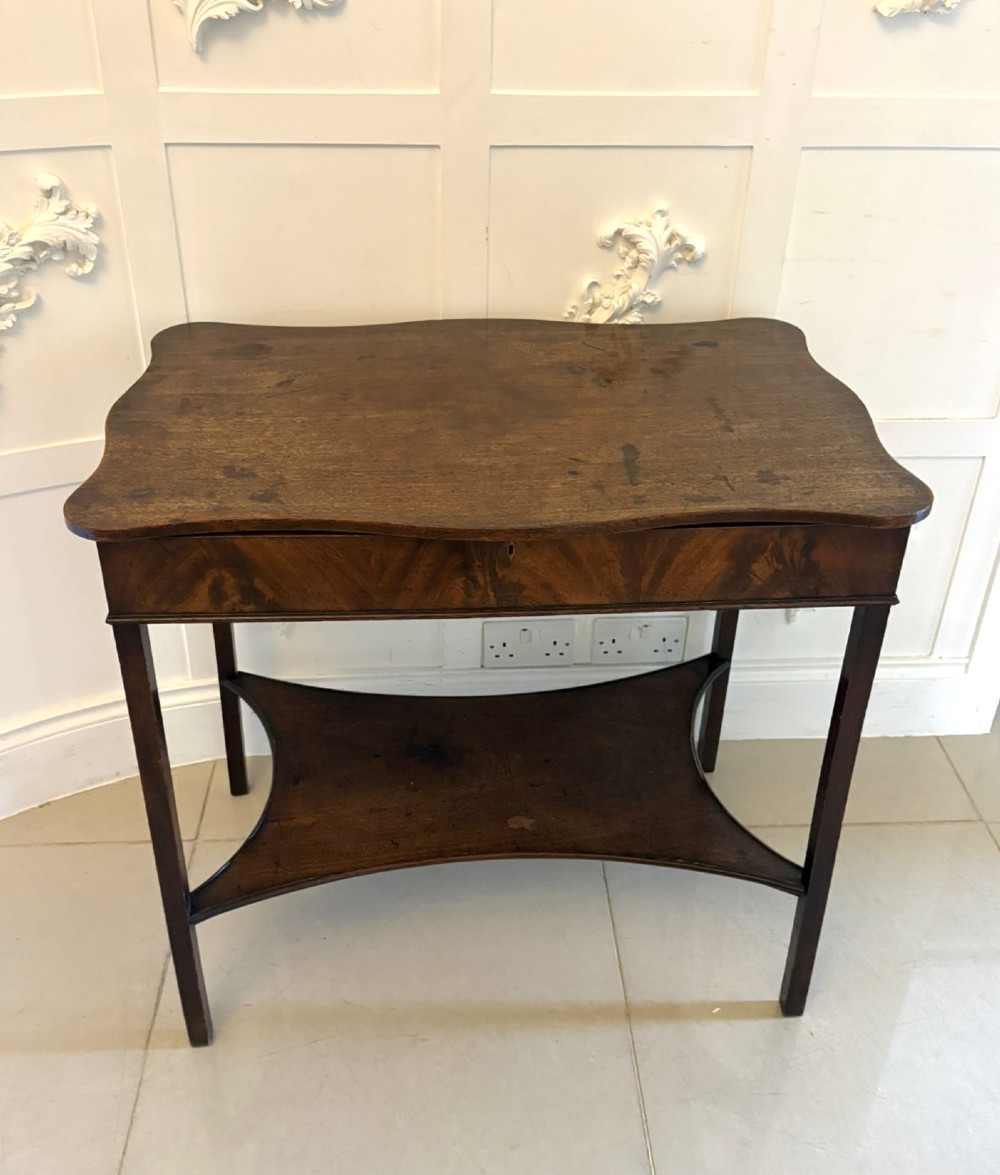 An antique mahogany dressing table with an open hinged lid displaying an internal mirror, storage compartments, side slides, and a shaped lower shelf. View IV