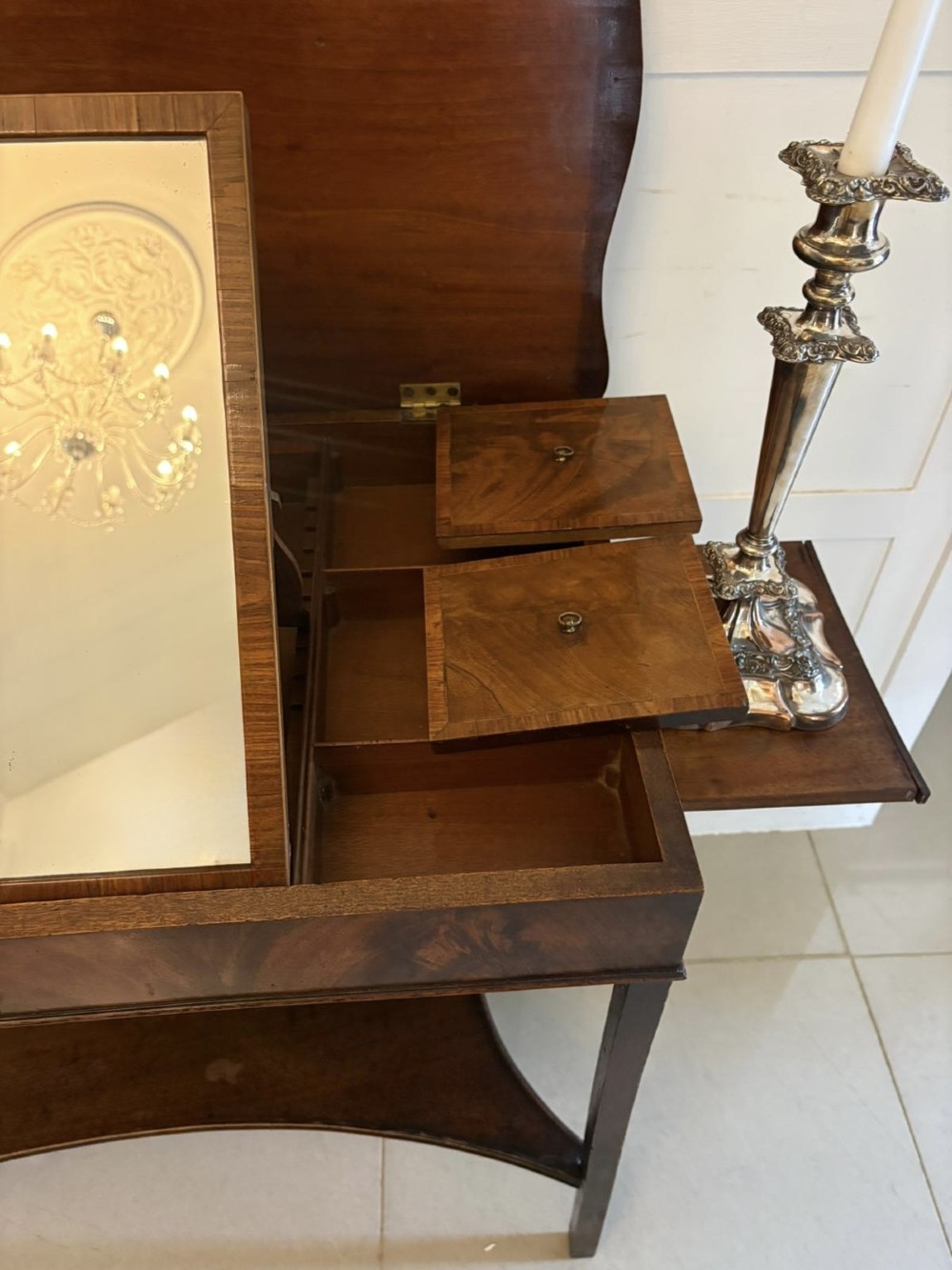 An antique mahogany dressing table with an open hinged lid displaying an internal mirror, storage compartments, side slides, and a shaped lower shelf. View X