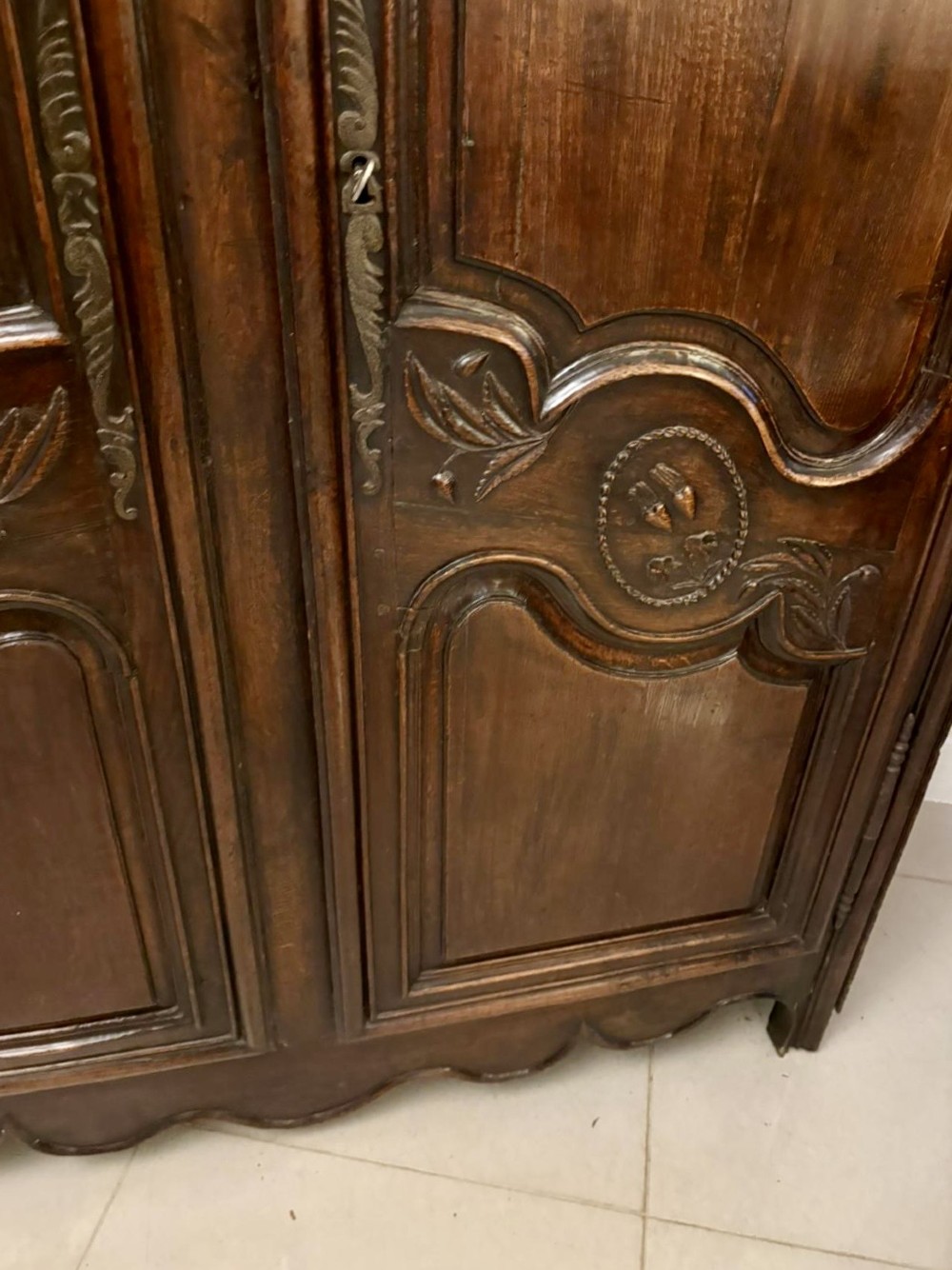 A late 17th-century French Provincial dark oak armoire featuring two doors with carved arched panels and a scalloped lower apron. View VII