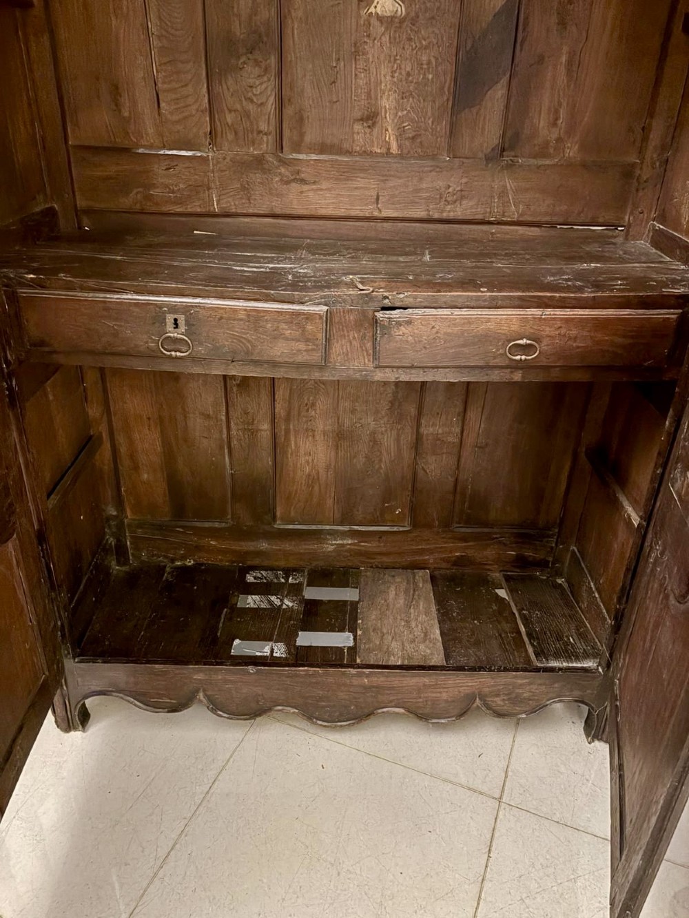 A late 17th-century French Provincial dark oak armoire featuring two doors with carved arched panels and a scalloped lower apron. View VIII