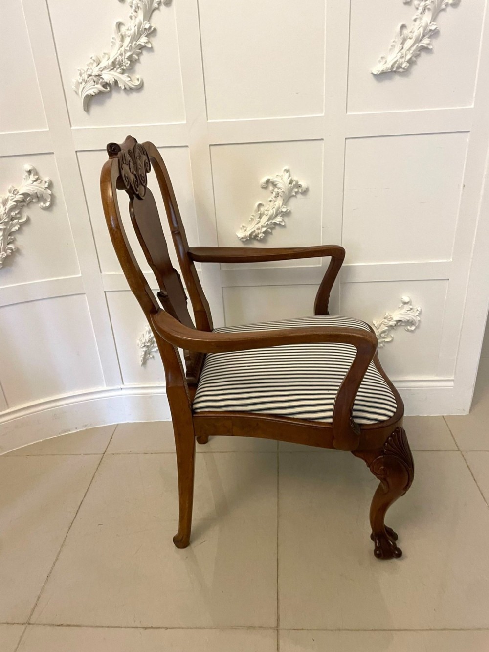 A set of twelve Victorian burr walnut dining chairs featuring carved splats, striped upholstered seats, and cabriole legs terminating in claw and ball feet. View IV