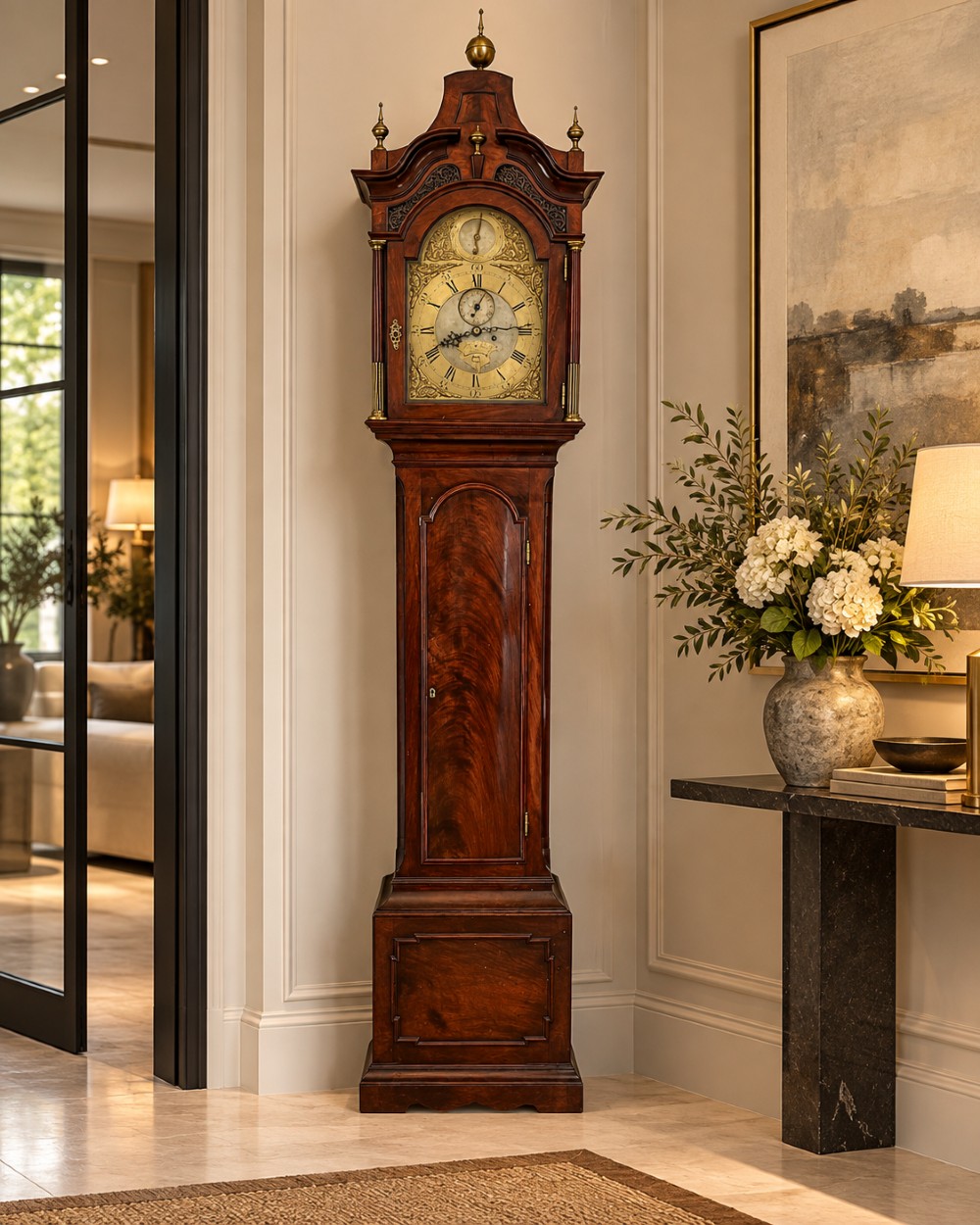 An antique Georgian longcase grandfather clock crafted from flame mahogany wood with an arched brass dial and brass finials. View II
