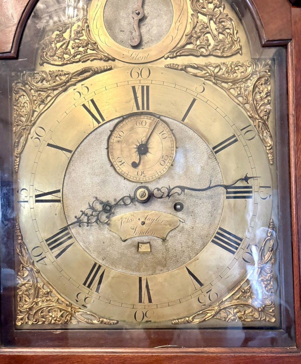 An antique Georgian longcase grandfather clock crafted from flame mahogany wood with an arched brass dial and brass finials. View XI