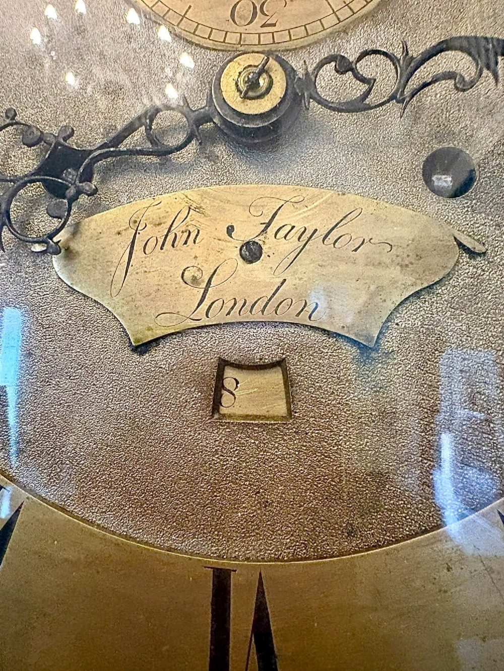 An antique Georgian longcase grandfather clock crafted from flame mahogany wood with an arched brass dial and brass finials. View XIII