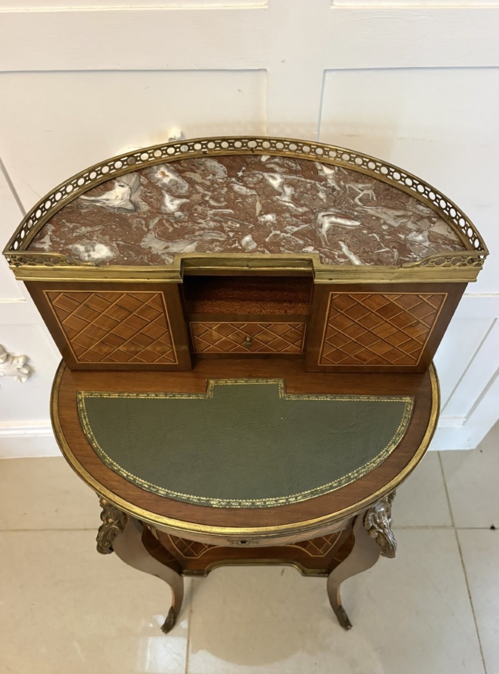 A French kingwood parquetry bonheur du jour writing desk featuring a green leather inset, marble top gallery, and gilt-bronze mounts on slender cabriole legs. View IX